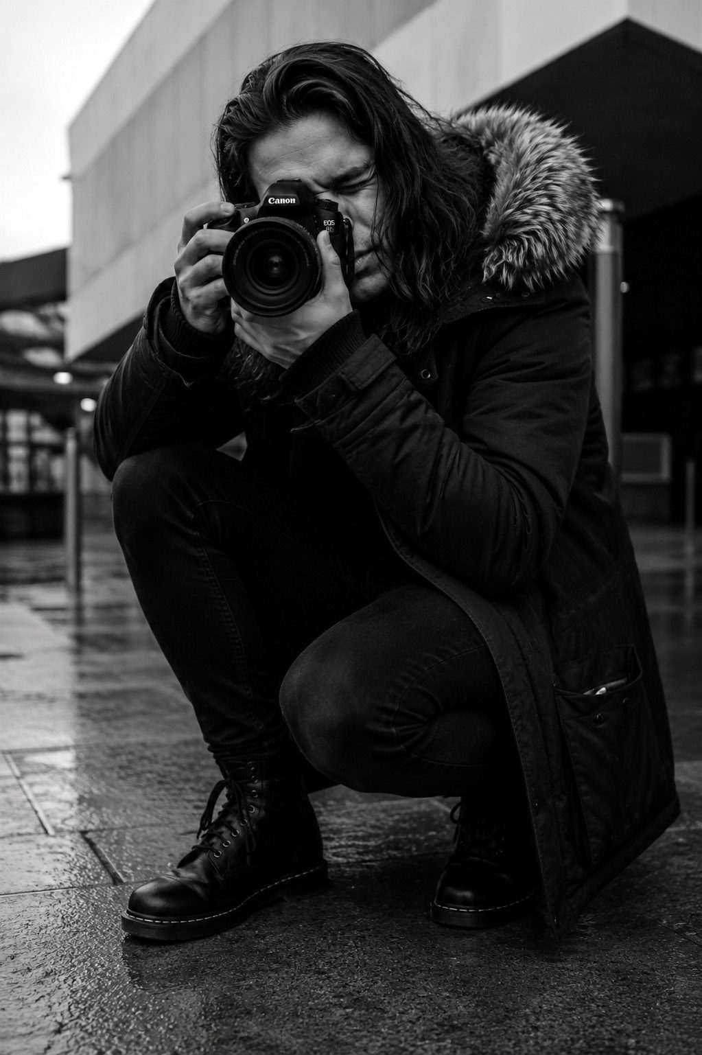 Aidan photographing on a wet city street